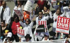  ?? AP PHOTO/REED SAXON ?? In this March 23, 2017, file photo, health care profession­als join hundreds of people marching through downtown Los Angeles protesting President Donald Trump’s plan to dismantle the Affordable Care Act.