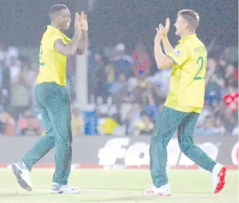  ??  ?? Ngidi (left) celebrates with teammate Dwaine Pretorius after dismissing England’s Moeen Ali during the first T20 cricket match between South Africa and England at the Buffalo Park Cricket Grounds in East London on February 12, 2020. - AFP photo
