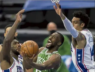  ?? Ap ?? Boston Celtics guard Kemba Walker shoots between philadelph­ia 76ers center Joel embiid, left, and forward danny Green during Wednesday’s game.