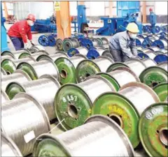 ?? AFP/CHINA OUT ?? Workers move rolls of aluminium at a factory in Zouping in China’s eastern Shandong province on Saturday.