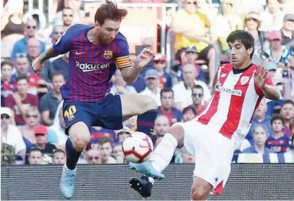  ?? Associated Press ?? Barcelona’s Lionel Messi (left) duels for the ball with Athletic Bilbao’s Mikel San Jose during their Spanish League match on Saturday.