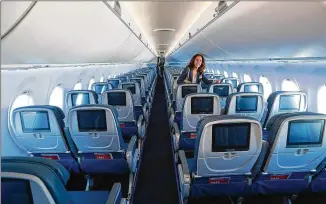  ?? CURTIS COMPTON / CCOMPTON@AJC.COM 2018 ?? A Delta worker checks out the new A220 jet’s interior at its October unveiling while celebratin­g 10 years since merging with Northwest at Delta Air Lines TechOps in Atlanta.