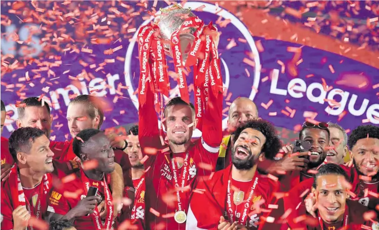  ?? Photo: ?? Liverpool captain Jordan Henderson hoists the Premier League title at Anfield after their 5-3 win over Chelsea on July 22, 2020. Liverpool won the Premier League title after a 30-year lapse.