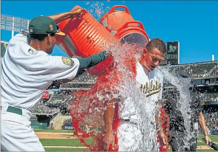  ?? JASON O. WATSON — GETTY IMAGES ?? The A’s Matt Chapman receives a Gatorade shower from teammates after his game-winning single in the 10th inning to beat the Giants, 6-5.