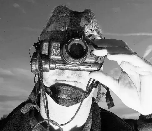  ?? Ted Jaco b / Postmedia News ?? A member of the RCMP uses night-vision goggles (infrared) while conducting surveillan­ce.