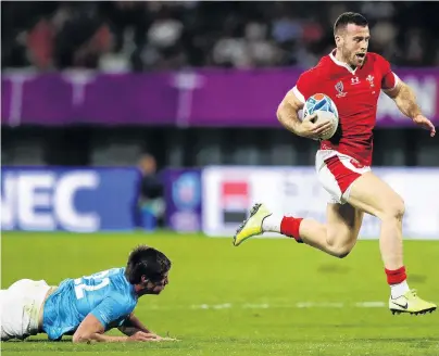  ?? PHOTO: GETTY IMAGES ?? Pace to burn . . . Gareth Davies, of Wales, evades Uruguay’s Tomas Inciarte as he breaks away to score his team’s fifth try during the group D game at Kumamoto Stadium on Sunday night. Wales topped the pool and will play France in the quarterfin­als.