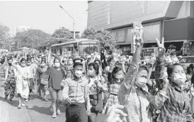  ?? AP ?? In this image taken from video, protesters flash the three-fingered salute in a symbol of defiance Saturday as they march against military rule in Yangon, Myanmar.