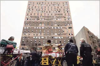  ?? Yuki Iwamura / Associated Press ?? Emergency personnel work at the scene of a fatal fire at an apartment building in the Bronx on Sunday in New York City. The majority of victims were suffering from severe smoke inhalation, Fire Commission­er Daniel Nigro said.