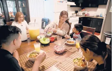  ?? GARY CORONADO/LOS ANGELES TIMES ?? Stephanie Contreras-Reyes, 17, center, eats homemade pozole with brother Ismael Contreras-Reyes, 13, from left, mother Teresa Reyes, brother Cristian Contreras-Reyes, 5, and sister Ashley Contreras-Reyes, 16, on Dec. 11 in Los Angeles. Stephanie is at the top of her class at Orthopaedi­c Hospital Medical Magnet High School.