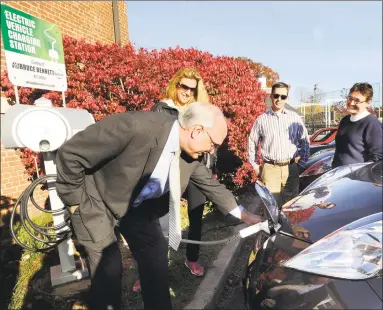  ?? Hearst Connecticu­t Media file photo ?? Ridgefield First Selectman Rudy Marconi demonstrat­es how the townowned electric car is charged at a charging station at the Ridgefield Playhouse in Ridgefield in 2013.