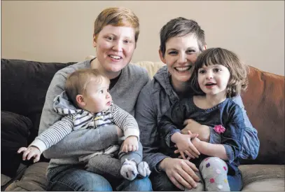  ??  ?? The Associated Press Jami Contreras, left, and her wife, Krista Contreras, pose for a photo with their children, Sylas and Bay, in Oak Park, Mich. Krista and Jamie took Bay to the doctor at 6 days old for her first doctor visit ; she was refused...