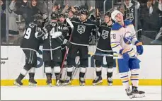  ?? Jayne Kamin-oncea / Associated Press ?? Buffalo defenseman Jacob Bryson, right, skates back to the bench as Kings right wing Alex Iafallo and teammates celebrate his game-winning goal on Sunday in Los Angeles.