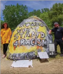  ??  ?? Abbey Clements, left, and Chris Lucero guard the Romeo Rock from the possibilit­y of it being painted over with racist wording again.