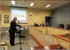  ?? DAN SOKIL — DIGITAL FIRST MEDIA ?? Attorney Jim Garrity, standing at center, shows plans for a proposed Royal Farms fuel station and convenienc­e store to Upper Gwynedd’s board of commission­ers and township staff on Monday night.