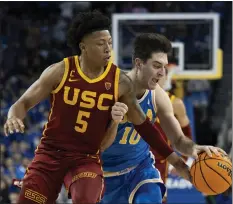  ?? KYUSUNG GONG — THE ASSOCIATED PRESS ?? USC guard Boogie Ellis, left, steals the ball from UCLA guard Lazar Stefanovic during the second half of Saturday night's rivalry game at Pauley Pavilion.