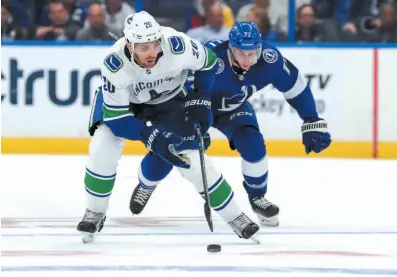  ?? AP PHOTO ?? Brandon Sutter of the Vancouver Canucks tries to pull away from Tampa Bay’s Anthony Cirelli during Thursday night’s game in Tampa, Fla.