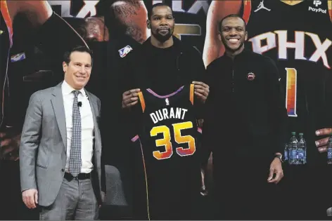  ?? AP PHOTO/MATT YORK ?? Phoenix Suns forward Kevin Durant (center) holds his jersey after being introduced during an NBA basketball team availabili­ty by owner Mat Ishbia (left) and general manager James Jones on Thursday in Phoenix.