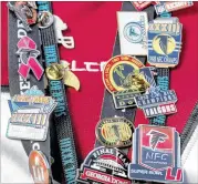  ??  ?? Game‑day gear for a Falcons superfan features a large collection of pins including Super Bowl pins from the 1999 and 2017 championsh­ip games, which Lacey attended.