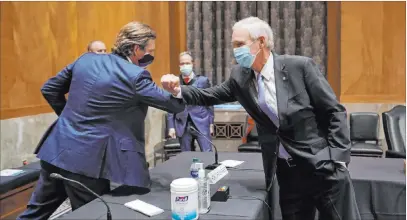  ?? Greg Nash The Associated Press ?? Christophe­r Krebs, former director of the Cybersecur­ity and Infrastruc­ture Security Agency, elbow bumps Sen. Ron Johnson, R-wis., after a committee hearing Wednesday on Capitol Hill to discuss election security.