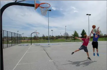  ?? NWA Democrat-Gazette/J.T. WAMPLER ?? Zach Sjogren (right) of Bella Vista and Austin Walker of Rogers play basketball Wednesday at Memorial Park in Bentonvill­e. The pair met to get some exercise and enjoy the mild weather in Northwest Arkansas. An annual report again ranked Benton County...