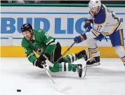  ?? LM Otero/Associated Press ?? Dallas Stars center Joe Pavelski reaches for the puck next to Buffalo Sabres center Tyson Jost during the first period an NHL hockey game in Dallas on Tuesday.