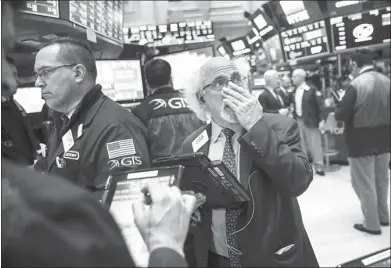  ?? AFP ?? Anxious traders at work on the floor of the New York Stock Exchange on March 26, when the world’s bourses re-opened for the week’s trading. The previous week was tumultuous, which saw leading indexes and stocks across the board slump on fears of a...