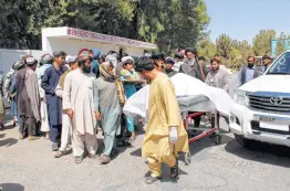  ?? Noor Mohammad / AFP/Getty Images ?? Afghan villagers carry a body on a stretcher outside a hospital Monday following an airstrike in Lashkar Gah, the capital of Helmand province.