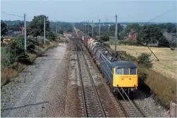  ?? DAVID CLOUGH. ?? Contrast the almost-diminutive AC electric 85009 with the DC machines built for the Woodhead route, as well as the much lighter electrific­ation structures at Balshaw Lane Junction (north of Wigan) on August 9 1984.