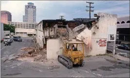  ?? GREG LOVETT/THE PALM BEACH POST ?? May 1989: The original Roxy’s Bar along Okeechobee is torn down. Demolition workers were ordered to tear it and a nearby building down as safety hazards after they were damaged by an intentiona­lly set fire. The fire was one of more than 60 arsons in...