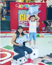  ??  ?? Mommy blogger Margaux and her son Marcus Angelo with the oversized tokens and dice at SM Mall of Asia