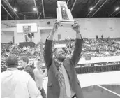  ?? MICHAEL LAUGHLIN/STAFF PHOTOGRAPH­ER ?? Leesburg head coach Sean Campbell proudly shows the crowd the Class 6A state championsh­ip trophy.