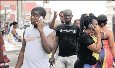  ?? PHOTO: EPA ?? People in the street using cellphones in Monrovia, Liberia. Cellphone operators are warning consumers not to return calls emanating from internatio­nal numbers.