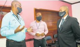  ??  ?? Agricultur­e and Fisheries Minister Floyd Green (right) listens attentivel­y to Acting Chief Executive Officer of the Jamaica Dairy Developmen­t Board Everton Parkes (left). At centre is project coordinato­r in the Projects Unit of the board, Devon Paul Sayers.