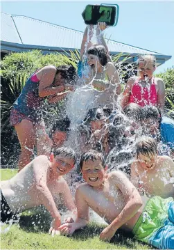  ?? Photo: REBECCA WILLIAMS ?? Drenched: Children from Queenspark Primary School in Christchur­ch enjoying a hot afternoon on their last day of school.