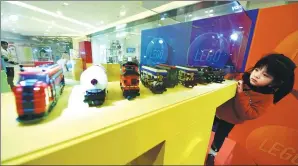  ?? LONG WEI / FOR CHINA DAILY ?? A girl watches locomotive models made of Lego chips in Hangzhou, capital of Zhejiang province.
