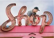  ?? ?? Mike Ryan rigs up the removal of the Pig Stand’s “Coffee Shop” sign, a reflective red wonder that dates back to the late 1940s or early 1950s.