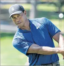  ?? AP PHOTO ?? Tiger Woods chips the ball to the ninth hole during a practice round for the BMW championsh­ip golf tournament at the Aronimink Golf Club in Newtown Square, Pa., Tuesday.