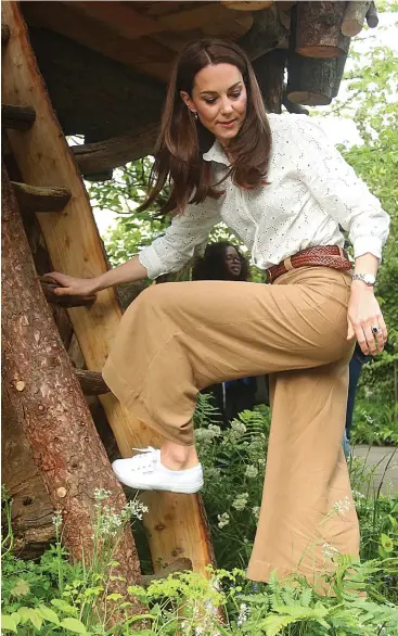  ??  ?? Royal ascent: The Duchess of Cambridge climbs a treehouse ladder in her garden