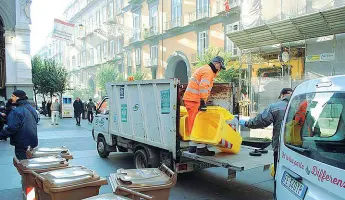  ??  ?? In strada Addetti dell’Asìa per le vie di Napoli mentre distribuis­cono i nuovi contenitor­i per la raccolta differenzi­ata dei rifiuti