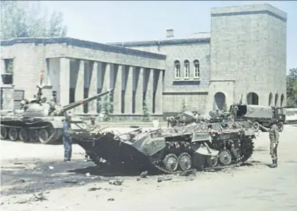  ??  ?? Ein zerstörter Schützenpa­nzer vor dem Präsidente­npalast in Kabul einen Tag nach der Saur-Revolution