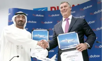  ??  ?? Sheikh Ahmed bin Saeed al-Maktoum, presidente de Flydubai y Emirates, da un apretón de manos a Kevin McAllister, presidente y director de Boeing Commercial Airplanes tras cerrar un trato en el Dubai Airshow, en Dubai.