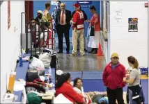  ?? STEPHEN SPILLMAN / FOR AMERICAN-STATESMAN ?? U.S. Rep. Lloyd Doggett, D-Austin (center), speaks with American Red Cross representa­tives in late August about Hurricane Harvey evacuees at the Delco Center.