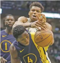  ?? MORRY GASH/THE ASSOCIATED PRESS ?? The Pacers’ Victor Oladipo, front, and the Bucks’ Giannis Antetokoun­mpo battle for a rebound Friday in Milwaukee. The Pacers won 103-96.