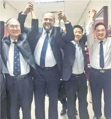  ??  ?? (From left) Siew Chiang and Gobind together with Tan and Chong raise their hands in victory outside the courtroom.