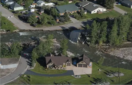  ?? DAVID GOLDMAN — THE ASSOCIATED PRESS ?? The entrance to Yellowston­e National Park, a major tourist attraction, is closed due to the historic floodwater­s last week that almost swept away a home in Gardiner, Mont. The park is facing its biggest challenge in decades.