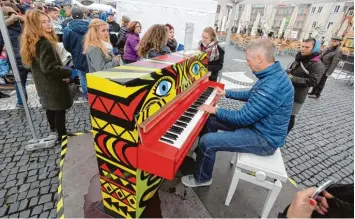  ?? Foto: Michael Hochgemuth ?? Von 9 bis 22 Uhr warten Straßenkla­viere in Augsburg auf Musikanten. Tobias Maier hat sich auf dem Rathauspla­tz hingesetzt und musiziert.