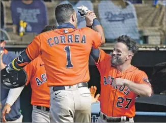  ?? CARLOS CORREA Kevork Djansezian Getty I mages ?? greets his Houston Astros teammate Jose Altuve ( 27) following Correa’s solo home run in the seventh inning against Oakland in Game 1 of the ALDS at Dodger Stadium.