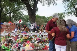  ?? MICHAEL M. SANTIAGO — GETTY IMAGES ?? People pray as they visit a memorial for the 19children and two adults killed on May 24 during a mass shooting at Robb Elementary School in Uvalde, Texas.