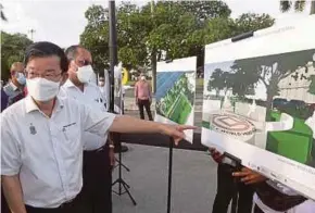  ?? (Foto Danial Saad/bh) ?? Kon Yeow menunjukka­n pelan projek Tembok Laut Padang Kota Lama siap dengan kos RM12.9 juta di Georgetown, semalam.