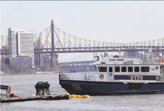  ?? Mark Lennihan / Associated Press ?? National Transporta­tion Safety Board officials examine the scene in New York City’s East River where a helicopter crashed. The pilot managed to survive, but five passengers died.